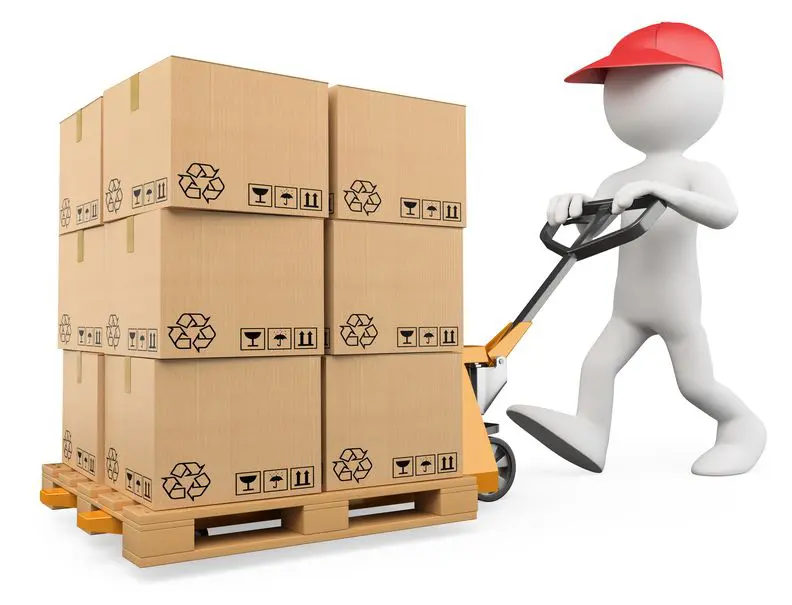 Warehouse worker pushing a full pallet using a pallet jack